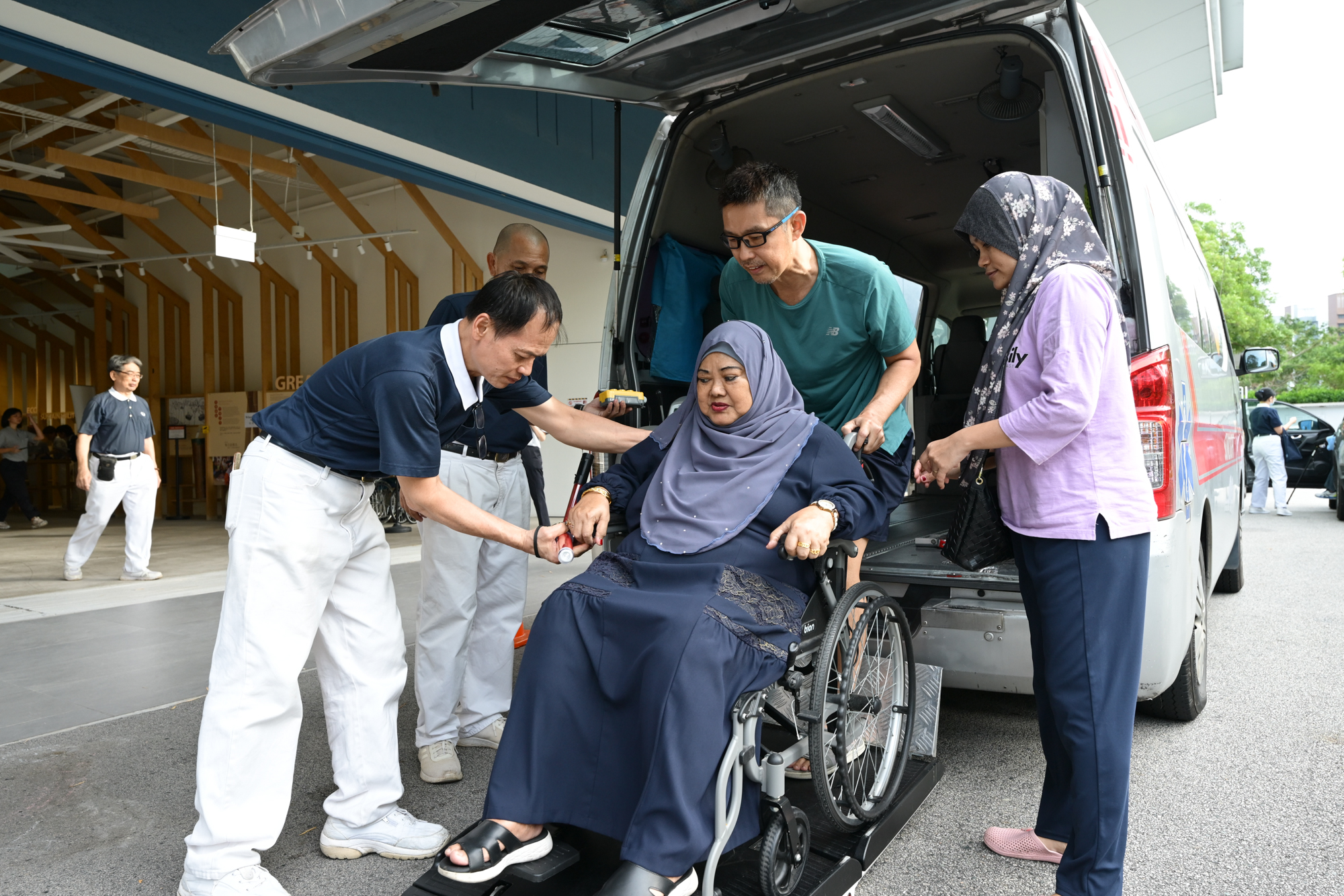 Care recipients with mobility issues were transported to the venue by caring volunteers. (Photo by Pua Poo Toong) 
