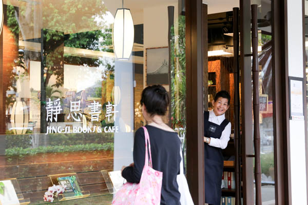 A staff of the book café invites an interested passerby to come in. Photo by Chua Teong Seng