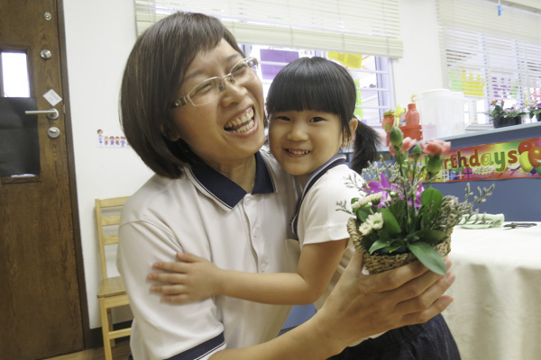 认为“花很美”的黄羽瑄把一盆花送给了老师陈丽华。摄 / 李晓婷