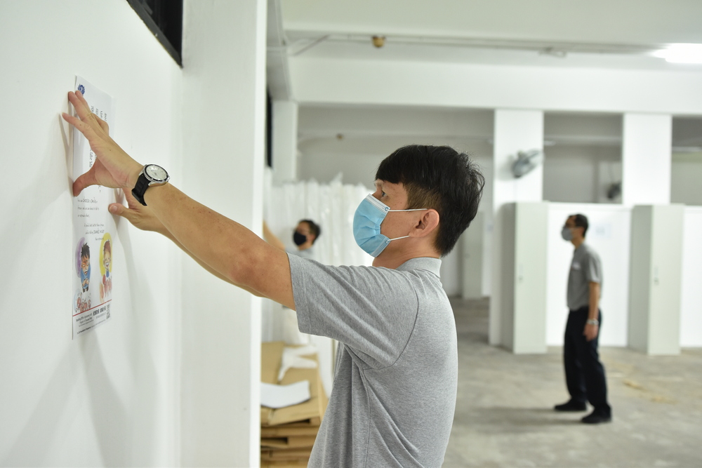 Volunteers are pasting Jing Si Aphorisms posters in unfurnished bedrooms. (Photo by Lai Tong Heng) 