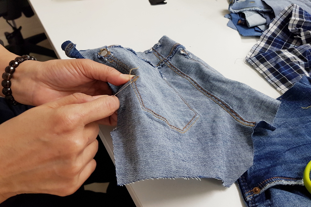 Removing buttons on the jeans is a tedious job. (Photo by Chan May Ching) 