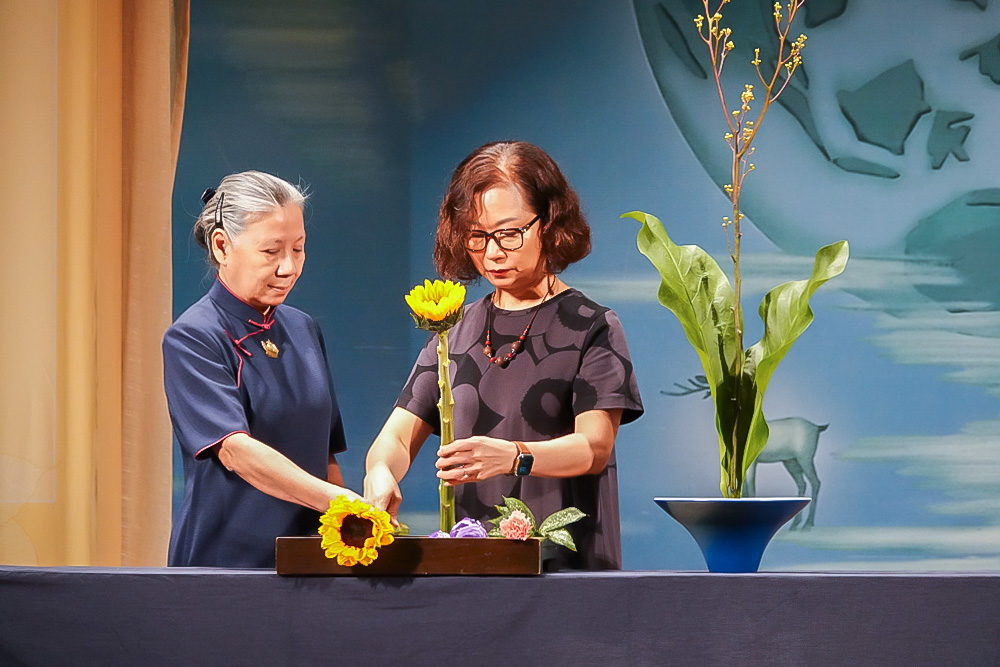 A floral art student demonstrating simple floral arrangements using leaves and flowers on stage. (Photo by Lee Foo Tien)